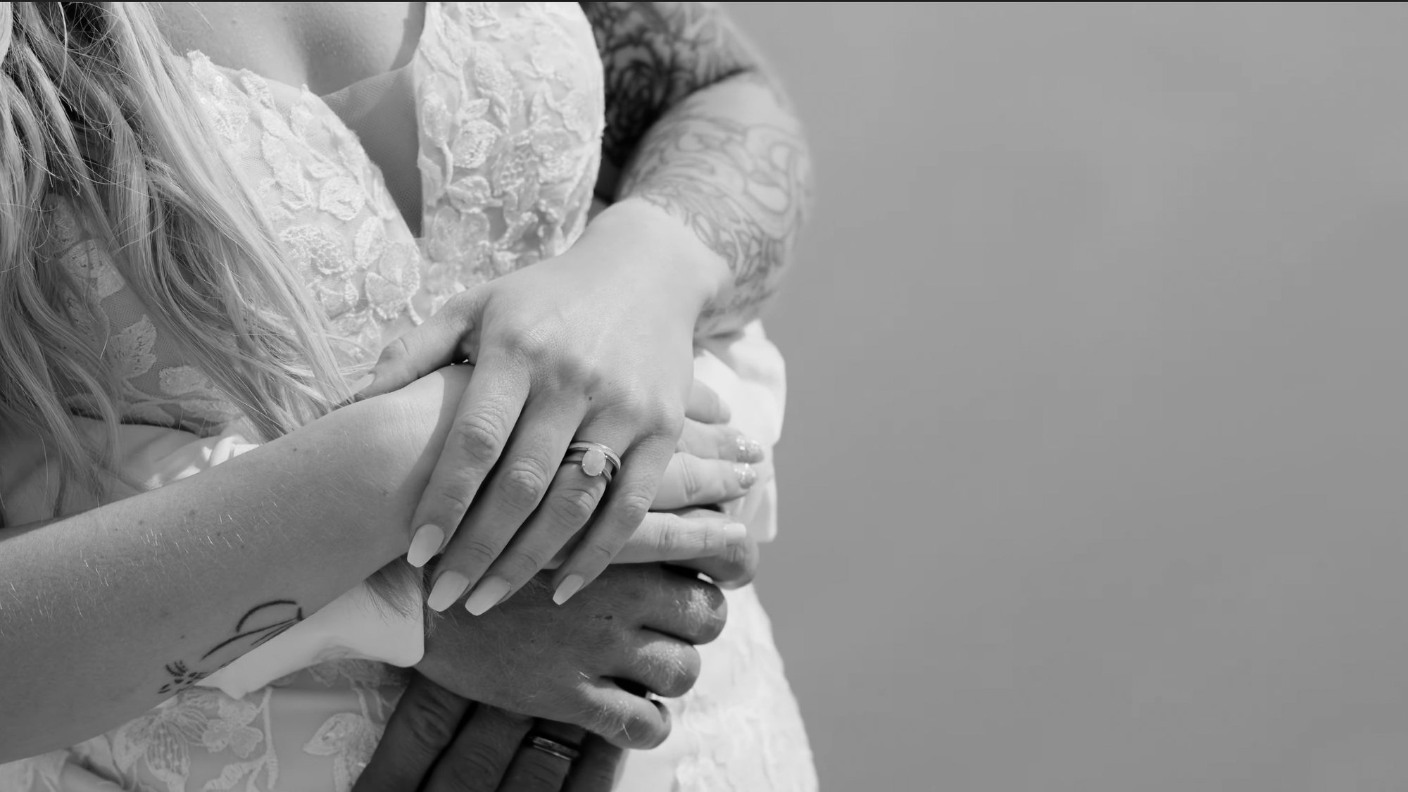 Black and white close-up of the couple’s hands resting together, the wedding ring in focus