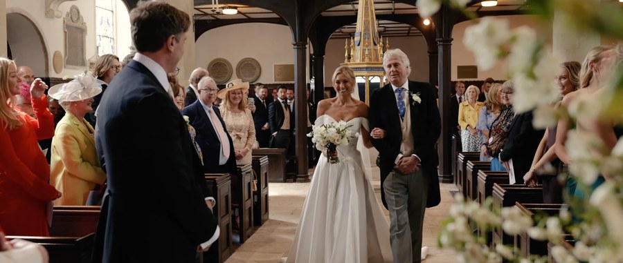 A bride walking up the aisle on her father's arm, playing in the review player.